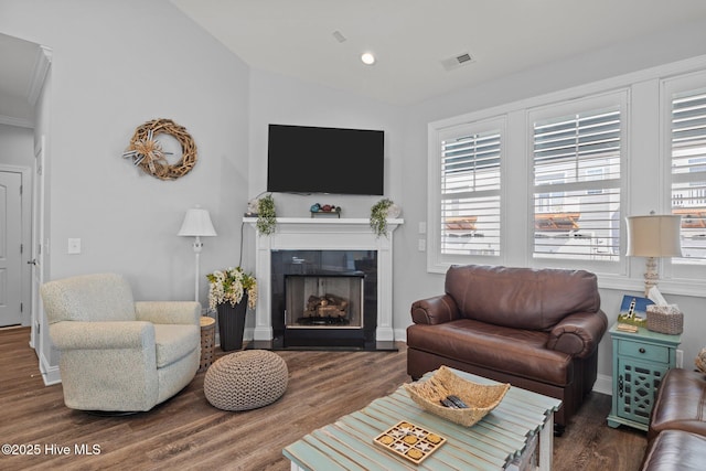 living area with vaulted ceiling, recessed lighting, visible vents, wood finished floors, and a tile fireplace