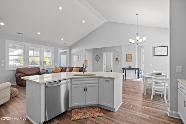 kitchen with open floor plan, stainless steel dishwasher, a sink, and light countertops