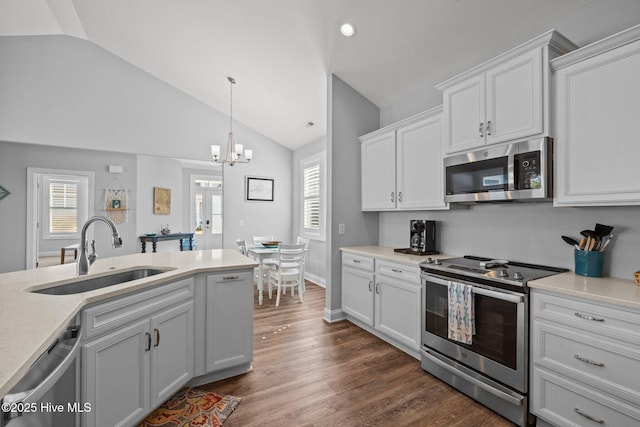 kitchen featuring vaulted ceiling, a chandelier, white cabinets, appliances with stainless steel finishes, and a sink