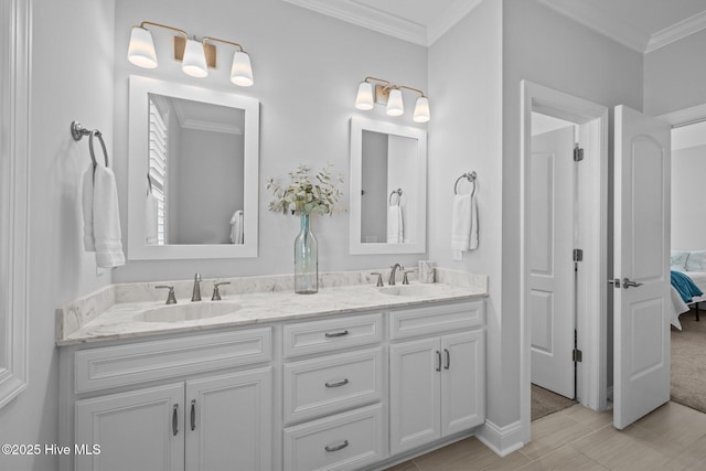 bathroom with a sink, ornamental molding, and connected bathroom