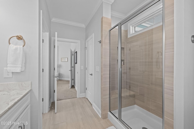 bathroom featuring a shower stall, vanity, baseboards, and crown molding