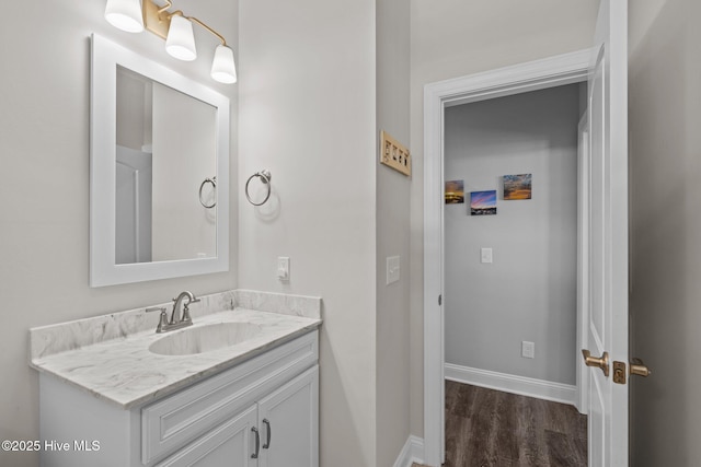bathroom featuring wood finished floors, vanity, and baseboards