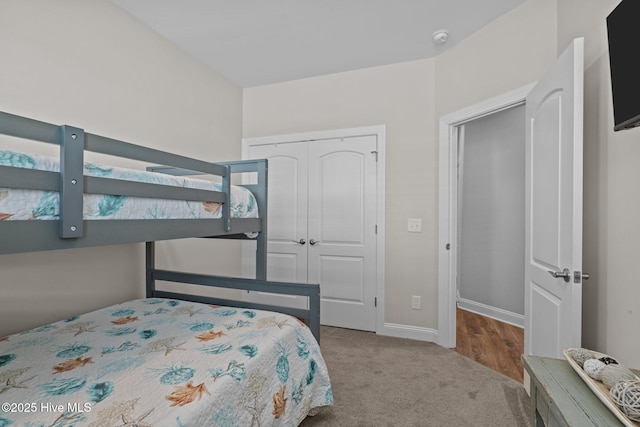 carpeted bedroom featuring a closet and baseboards
