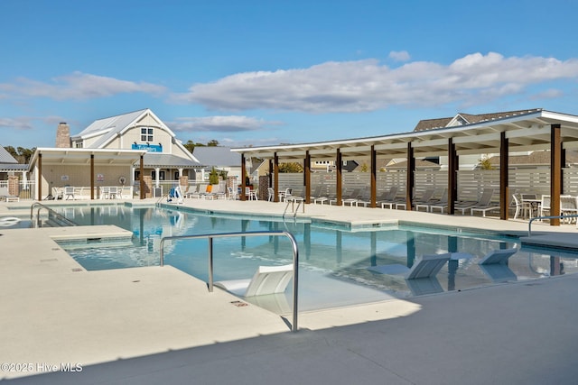 pool with a patio area and fence