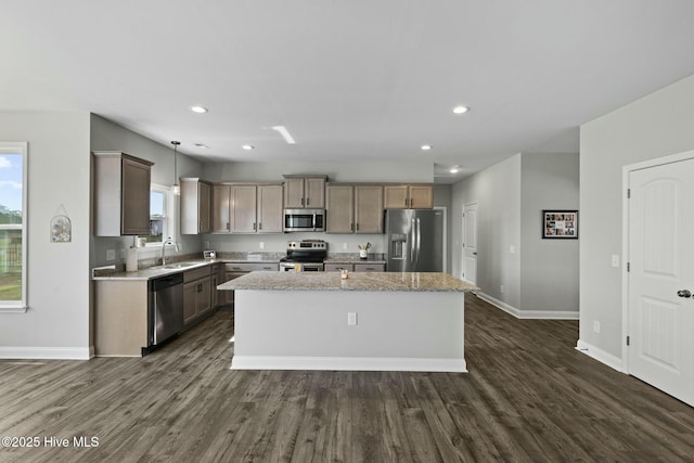 kitchen with dark wood-style flooring, baseboards, a center island, stainless steel appliances, and a sink