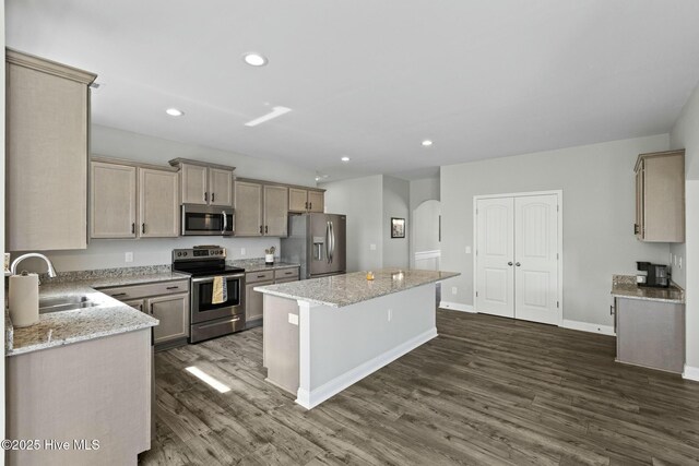 kitchen with recessed lighting, a kitchen island, dark wood-type flooring, stainless steel appliances, and a sink