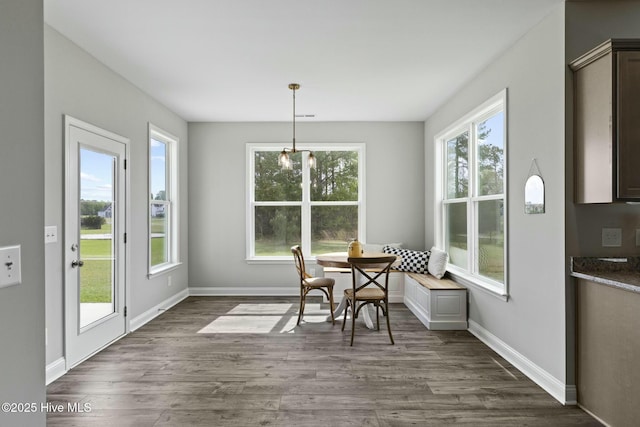 dining space with breakfast area, baseboards, and dark wood finished floors