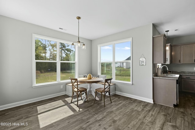 dining area with visible vents, baseboards, a notable chandelier, and dark wood finished floors
