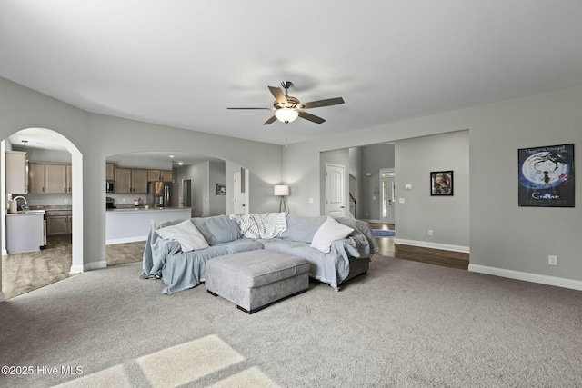 bedroom featuring arched walkways, baseboards, stainless steel refrigerator with ice dispenser, and carpet