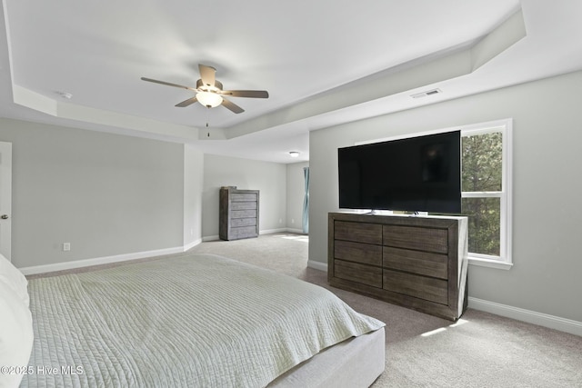 bedroom with a tray ceiling, baseboards, carpet, and visible vents