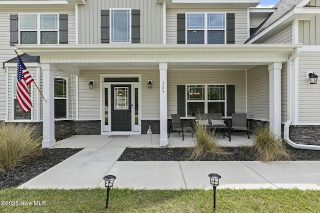 property entrance with a porch and stone siding