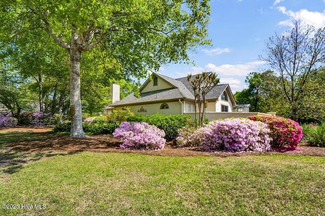 1957 Prestwick Ln, Wilmington, NC 28405 - view of side of property featuring stucco siding, a chimney, and a yard
