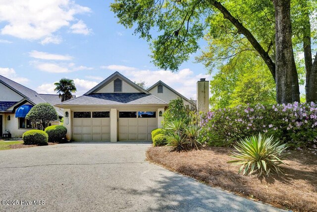 1957 Prestwick Ln, Wilmington, NC 28405 - view of front of home with a garage, concrete driveway, and a chimney