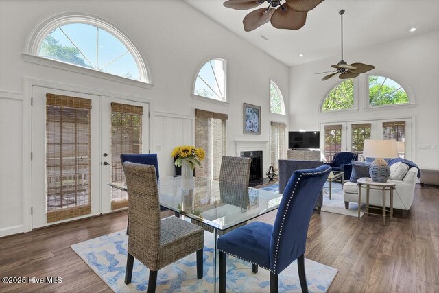 1957 Prestwick Ln, Wilmington, NC 28405 - dining room featuring ceiling fan, high vaulted ceiling, wood finished floors, a fireplace, and french doors