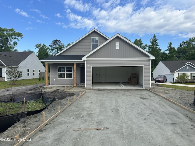 view of front of home with an attached garage, board and batten siding, a porch, and aphalt driveway