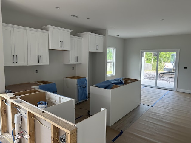 kitchen featuring white cabinetry, light wood finished floors, recessed lighting, and a center island