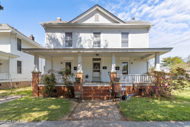 view of front facade with covered porch and a front lawn