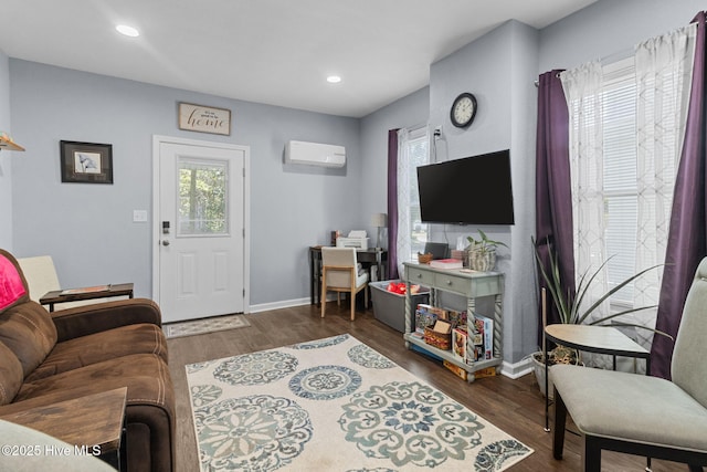 living room with recessed lighting, baseboards, a wall unit AC, and wood finished floors
