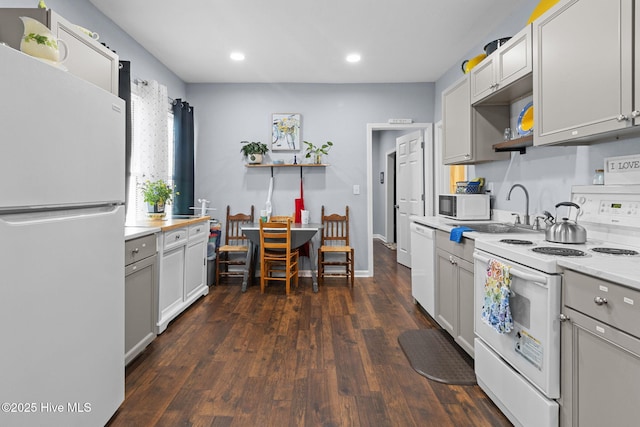 kitchen with recessed lighting, white appliances, light countertops, open shelves, and a sink