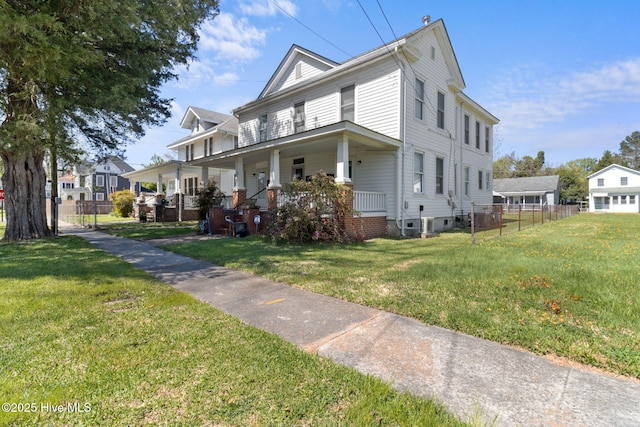 view of front of property with a front yard, fence, and covered porch