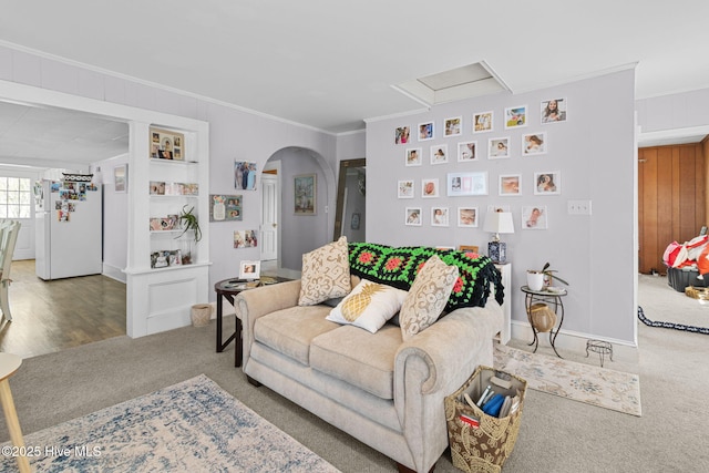 living room featuring crown molding, arched walkways, baseboards, and carpet flooring