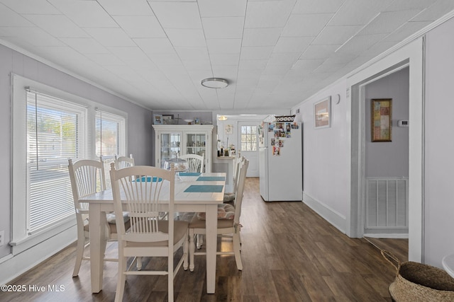 dining room featuring crown molding, visible vents, baseboards, and dark wood-style flooring