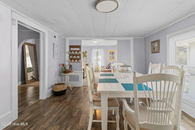 dining room with visible vents, ornamental molding, and wood finished floors