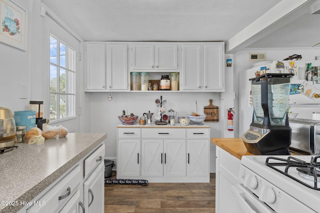 kitchen featuring open shelves, light countertops, dark wood finished floors, white cabinetry, and white gas range oven
