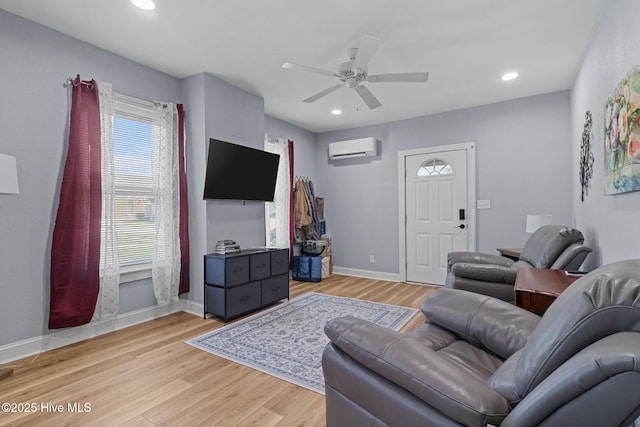 living area with baseboards, a ceiling fan, light wood-style floors, recessed lighting, and a wall unit AC