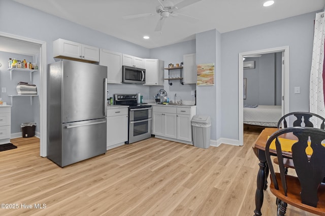kitchen featuring open shelves, a wall mounted air conditioner, appliances with stainless steel finishes, a ceiling fan, and light wood-style flooring