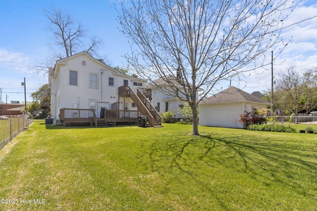 back of house with fence, a wooden deck, and a lawn