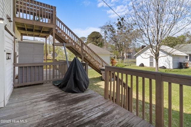 wooden terrace featuring stairs and a lawn