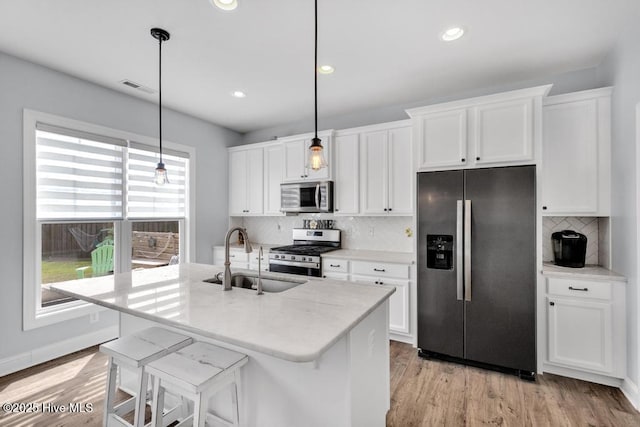 41 S Lamplighters Walk, Hampstead, NC 28443 - kitchen with stainless steel appliances, a sink, a kitchen island with sink, white cabinets, and light wood-style flooring