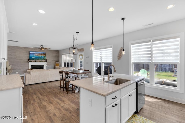 41 S Lamplighters Walk, Hampstead, NC 28443 - kitchen featuring a sink, ceiling fan, dishwasher, a fireplace, and white cabinetry