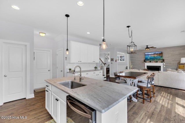 41 S Lamplighters Walk, Hampstead, NC 28443 - kitchen featuring stainless steel dishwasher, a sink, ceiling fan, a fireplace, and wood finished floors