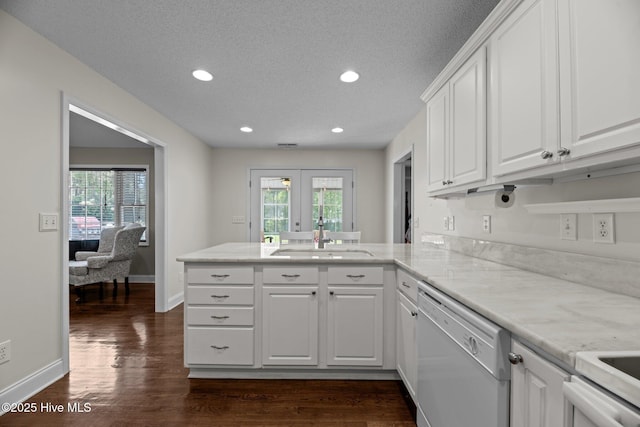 kitchen featuring a peninsula, a healthy amount of sunlight, dishwasher, and a sink