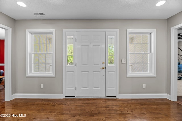 foyer with visible vents, baseboards, a textured ceiling, recessed lighting, and wood finished floors