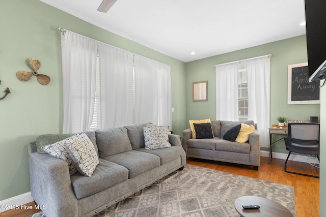 living room with wood finished floors, baseboards, and recessed lighting
