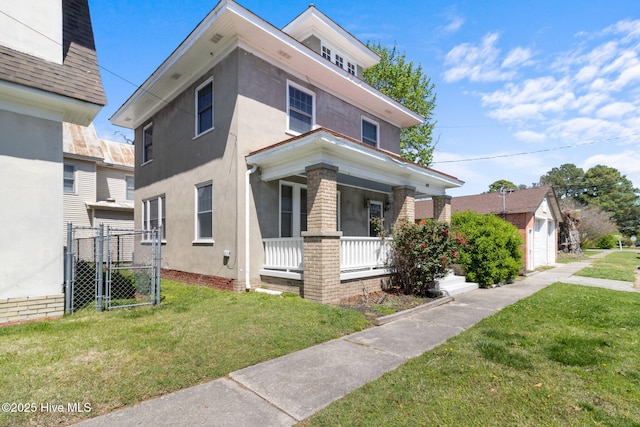 view of front of home featuring a porch, stucco siding, a front lawn, and a gate