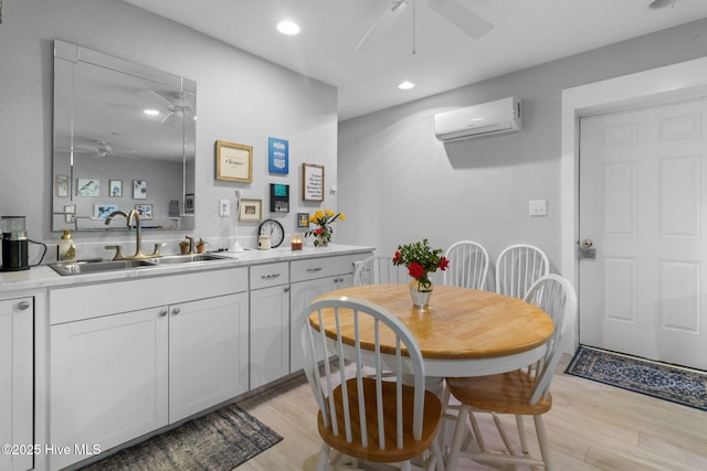 dining room with light wood-type flooring, a ceiling fan, recessed lighting, and a wall mounted air conditioner