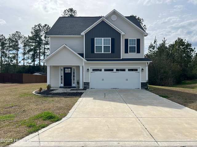 view of front of house with driveway, fence, a garage, and a front lawn