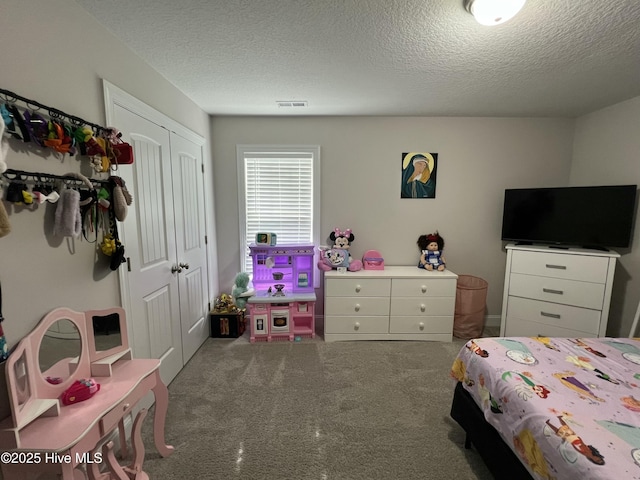 carpeted bedroom featuring visible vents, a closet, and a textured ceiling