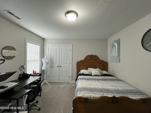 carpeted bedroom featuring visible vents, a closet, and a textured ceiling