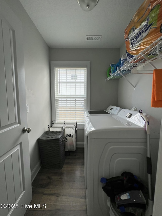 washroom with visible vents, baseboards, washer and dryer, laundry area, and wood finished floors