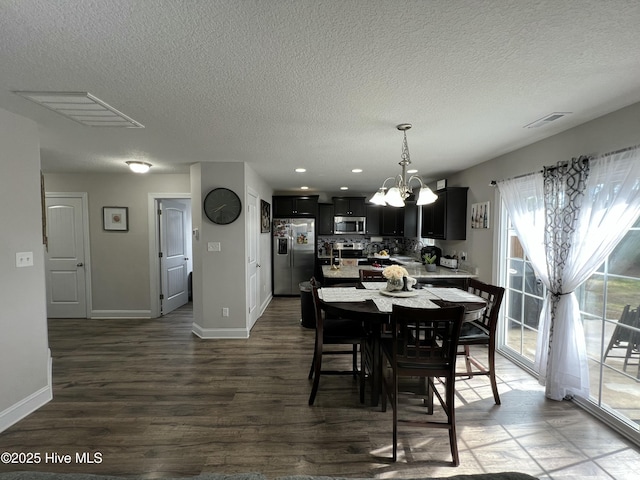 dining room featuring visible vents, baseboards, a notable chandelier, and dark wood-style floors