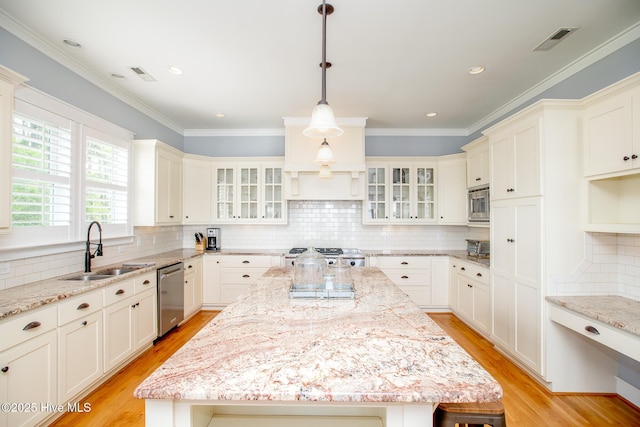 kitchen featuring visible vents, tasteful backsplash, a sink, light wood-style floors, and stainless steel appliances