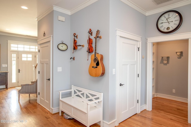 hall with crown molding, visible vents, light wood-style floors, baseboards, and recessed lighting
