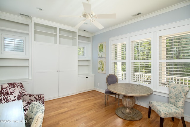 sitting room featuring baseboards, visible vents, ornamental molding, and light wood-type flooring