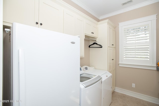 laundry area featuring visible vents, ornamental molding, baseboards, washing machine and clothes dryer, and cabinet space