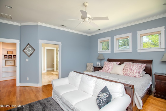 bedroom featuring visible vents, baseboards, crown molding, and wood finished floors